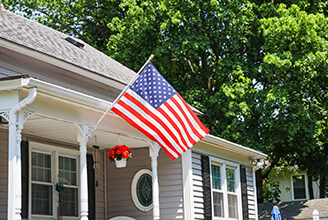 House with American flag hanging in the front.