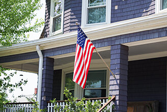 House with American flag hanging in the front.