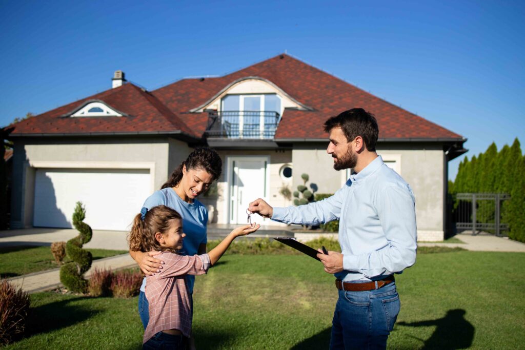 Real estate agent handing over keys of the new house to the single mother with her child.
