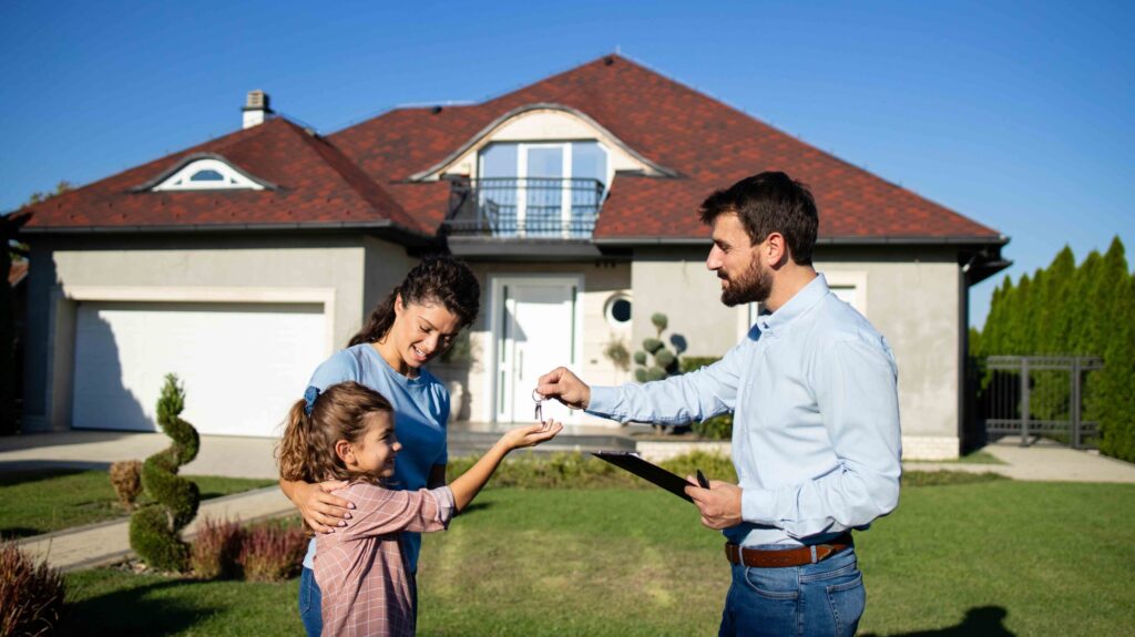 Real estate agent handing over keys of the new house to the single mother with her child.
