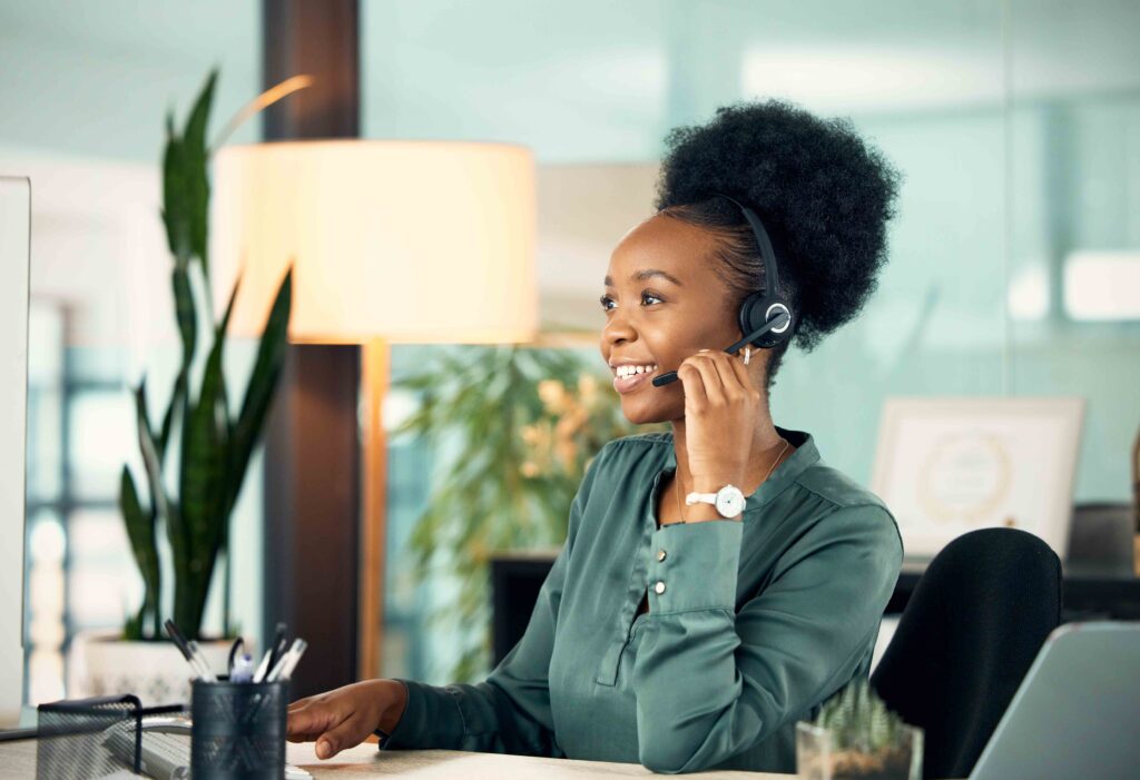 Call center, black woman and smile for telemarketing, business or customer service in office for deadline. Contact us, crm and African female sales agent, support consultant or professional at night