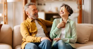 Retired couple laughing on the couch