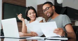 Couple smiling while reviewing documents