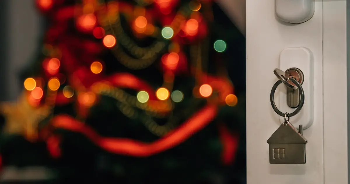 Key in door with Christmas tree in background