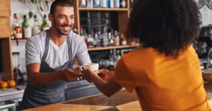 Barista handing coffee to customer